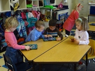 Young children engaged with an iPad